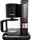 Zwarte Bosch koffiezetapparaat met glazen kan met koffie en waterreservoir.