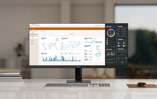 LG monitor op een bureau met grafieken en data-analyse op het scherm. Twee boeken ernaast.