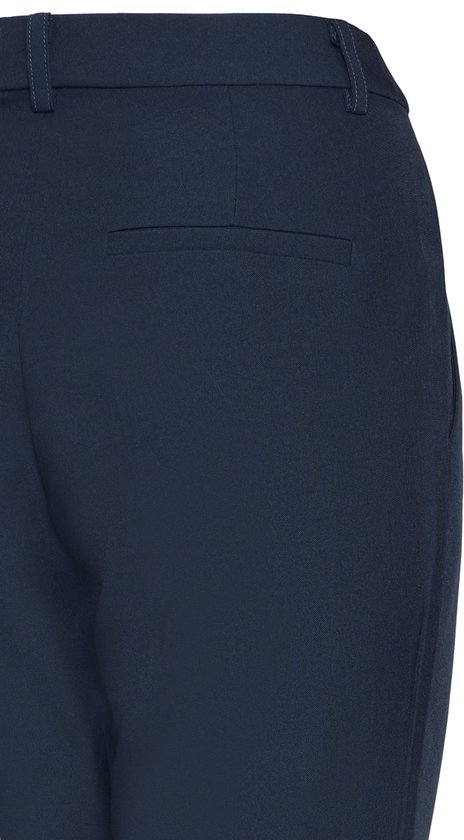 Achterkant van een donkerblauwe broek met wijde pijpen, detail van de zak.