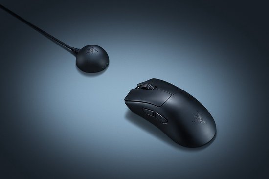 Zwarte Razer gaming muis en ronde draadloze oplader met kabel.