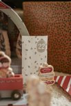 Wit adventszakje met takjes en sterretjes, met het cijfer 22 erop.