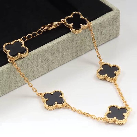 Gouden schakelarmband met vijf zwarte klavertjes, elk met een gouden rand.