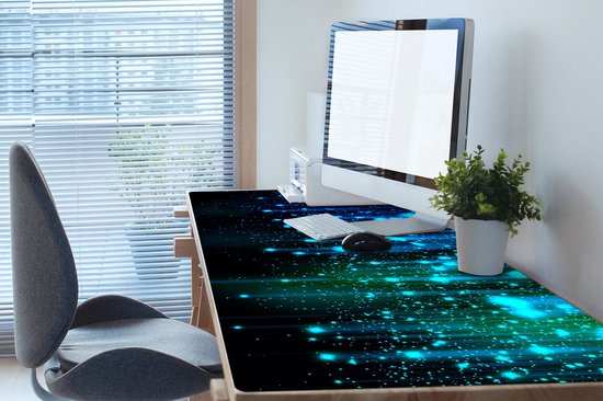 Sous-main avec des effets de lumière et de poussière d'étoiles bleues et vertes, avec un bureau et un ordinateur.