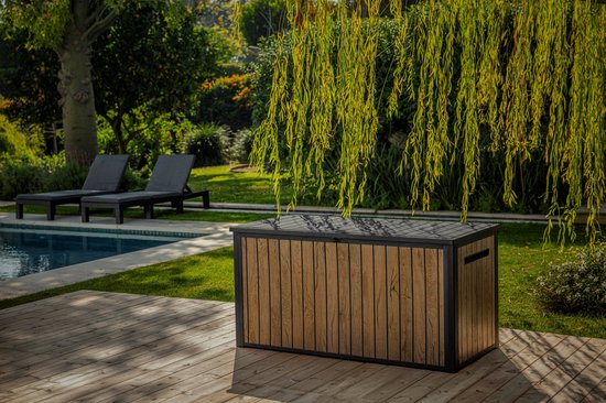 Houten opbergbox naast een zwembad en ligstoelen in een tuin.