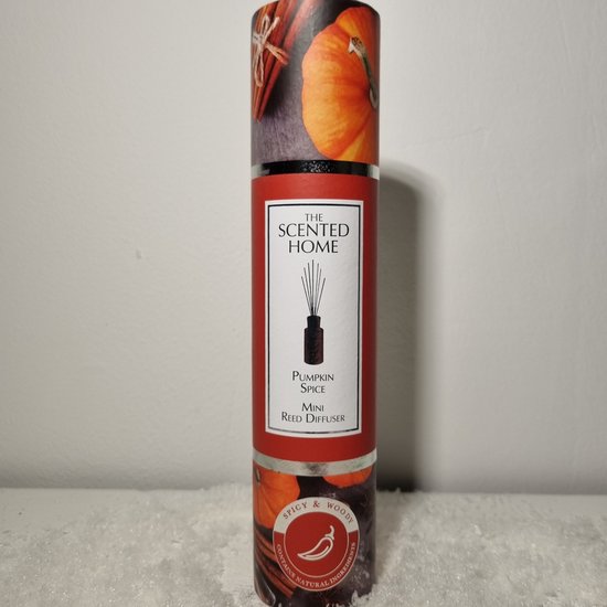 Mini reed diffuser met pompoen en kaneeldecoratie. Rood met witte tekst.