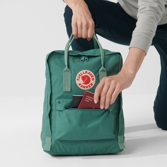Personen die een groene Kånken rugzak vullen met documenten.