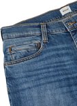 Detail van de tailleband en voorzakken van een blauwe spijkerbroek met Mustang label.