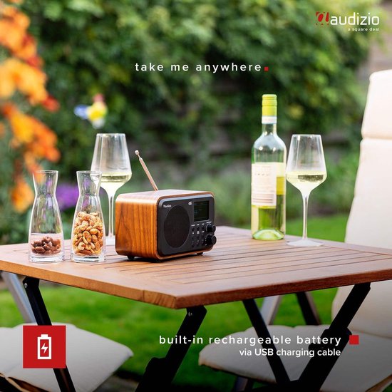 DAB radio met houtlook op een tuintafel met wijn en glazen.