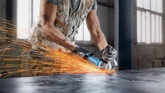 Man met gereedschapsvest slijpt metaal met een Bosch haakse slijper, vonken vliegen eraf.