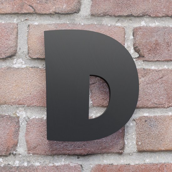 Zwart huisnummer bord 'D' op een bakstenen muur.