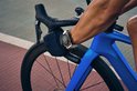 Renner op een racefiets met een smartwatch om de pols, met zweet op de arm.