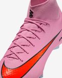 Sluit de roze Nike voetbalschoen met veters, rode swoosh en zwarte 'M' logo.