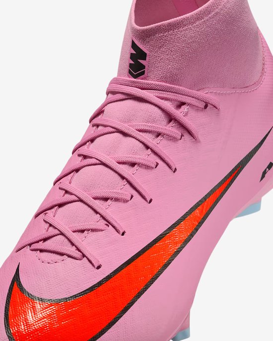 Sluit de roze Nike voetbalschoen met veters, rode swoosh en zwarte 'M' logo.