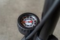 Close-up van een zwarte fietspomp met een drukmeter. De wijzer staat op 4.