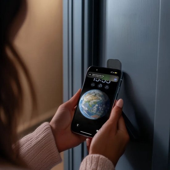 Handen houden een smartphone met een aarde-afbeelding op het scherm tegen een donkerblauwe deur.