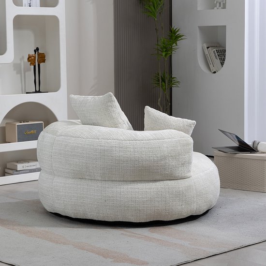 Witte fauteuil met twee kussens, zachte rondingen, in een woonkamer.