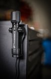 Zwarte Ledlenser P7R PRO zaklamp met een groene indicator, op een zwarte houder.