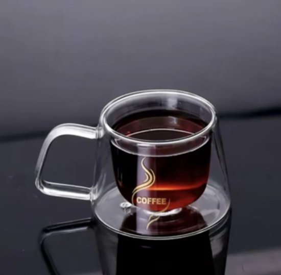 Dubbelwandige koffiemok van glas met handvat, gevuld met donkere vloeistof, met gouden 'COFFEE' logo.