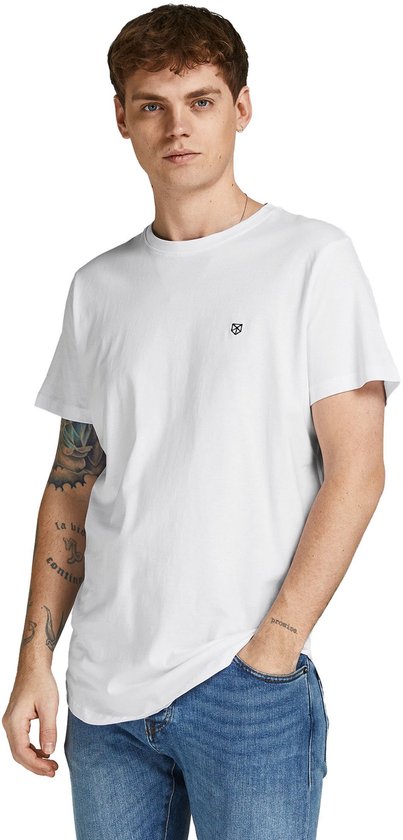 Wit t-shirt met ronde hals, korte mouwen en gebogen zoom, gedragen door een man met tatoeages.