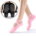 Roze no-show sokken op voeten, met gekruiste bandjes en antislip zool. Detail van de zolen met 'Yoga'.