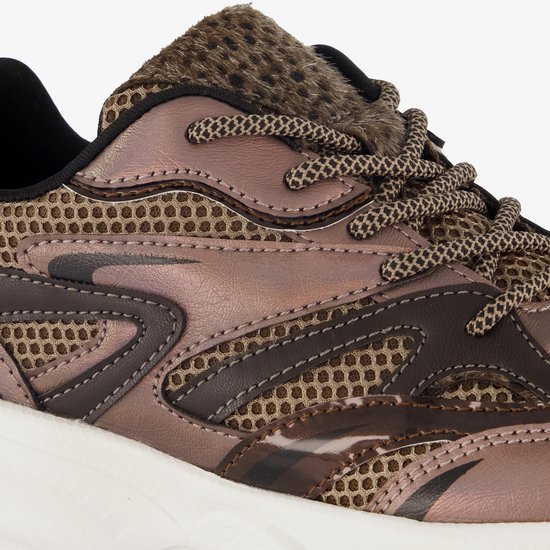 Close-up van bruine dad sneaker met mesh, metallic finish en panterprint.