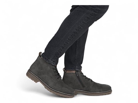 Man met zwarte jeans en grijze suède veterboots, één met ritssluiting.