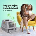 Grijze Jake & Jacky kattenbak met opstapje, naast een vrouw die een bruin-witte kat vasthoudt in een gele stoel. Munte symbolen met blaadjes.