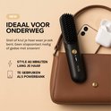 Zwarte MAE® stijlborstel in bruine handtas, naast smartphone en oordopjes.