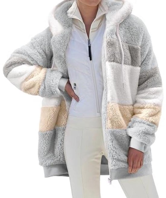 Model in een lange grijze, witte en beige colorblock teddy-fleece hoodie met capuchon, open geritst over een witte jas.