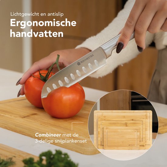 Een vrouw snijdt tomaten met een mes met ergonomische handgreep. Rechtsonder een stapel snijplanken.