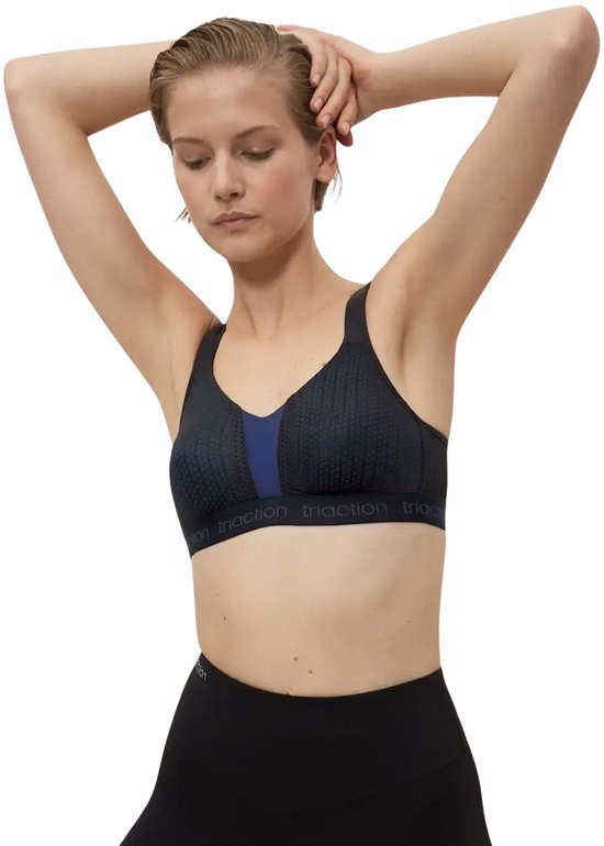 Zwarte sportbeha met blauwe stipjes en contrasterende blauwe inzet. Band met 'triaction'-logo, op model.