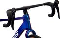 Close-up van het stuur en de voorvork van een blauwpaarse gravelbike.