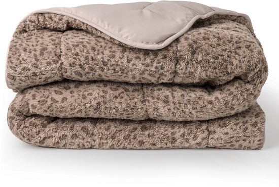 Couette teddy taupe pliée avec motif léopard et un bord retourné beige.