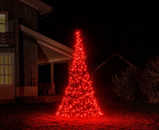 Een met rode ledlampjes versierde kerstboom voor een huis.