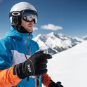 Man met skihelm en skibril draagt zwarte R2B handschoenen.