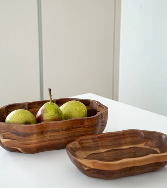 Twee houten schalen, één met peren en de andere leeg.