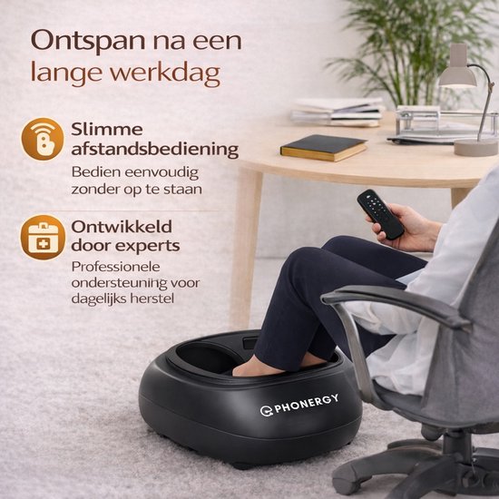 Zwart voetmassageapparaat van Phonergy in een kantooromgeving. Een persoon bedient het met een afstandsbediening.