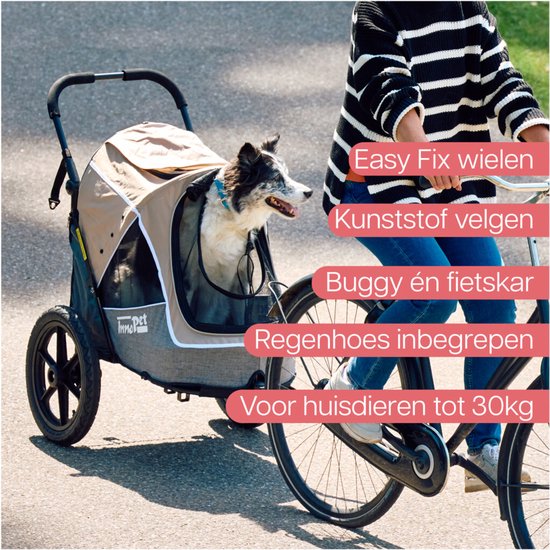 Hond in beige InnoPet fietskar, bevestigd aan een fiets. Met regenhoes, 360° draaiend voorwiel, bovenopening en fietsstang.