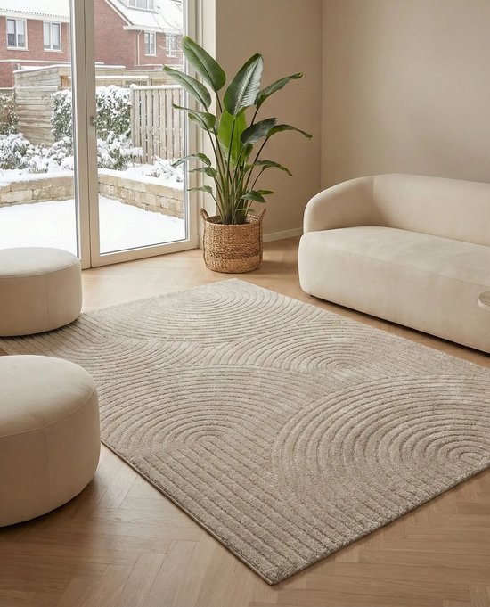 Beige vloerkleed met gebogen lijnen patroon in een woonkamer met witte poefs en een crèmekleurige bank.