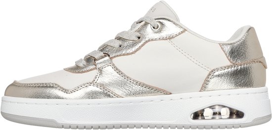 Zijaanzicht van een witte sneaker met champagnekleurige leren panelen, veters en een witte zool met luchtdemping.