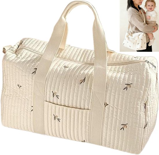 Sac de voyage matelassé beige avec rembourrage rayé et branches brodées. Avec poignées et poche avant. Une femme porte le sac dans l'encart.