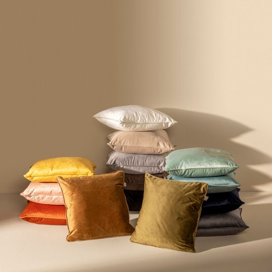 Stapel decoratieve kussens in verschillende kleuren, waaronder okergeel, oranje, koraal, mosgroen en taupe.