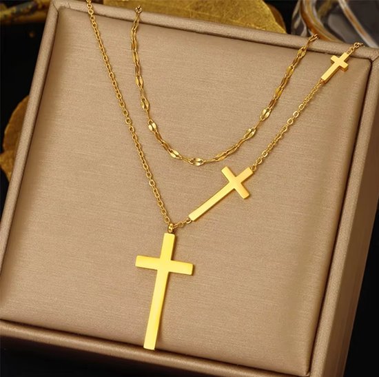 Gouden dubbele ketting met drie kruisjes, goudlook, op bruine achtergrond.