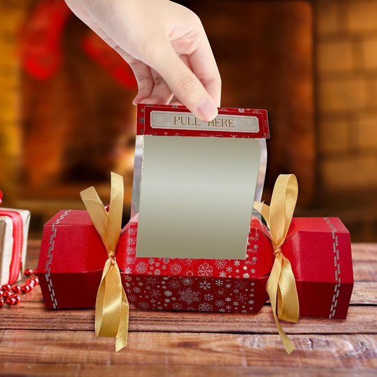 Hand trekt een geldband uit een rode kerstcadeauhouder met sneeuwvlokpatroon en strik.