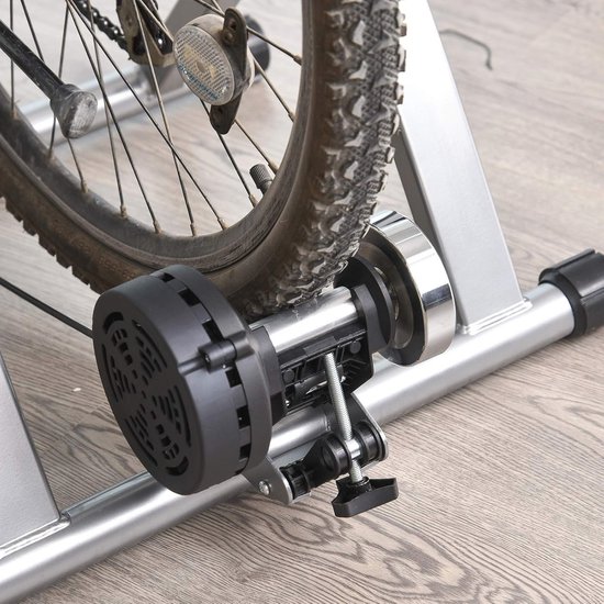 Close-up van de achterband van een fiets die op de fietstrainer is gemonteerd, met de magnetische weerstandseenheid.