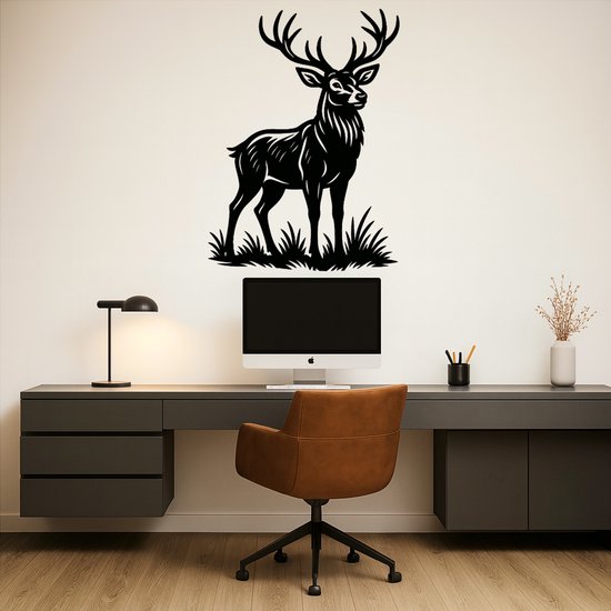 Décoration murale en métal noir d'un cerf avec bois, debout dans l'herbe. Monté au-dessus d'un ordinateur.