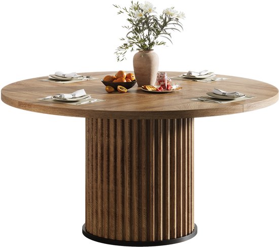 Ronde houten eettafel met geribbeld onderstel, gedekt voor vier personen.