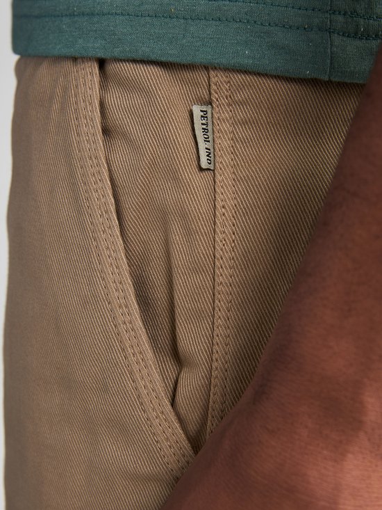 Zijnaad van een beige chino short met een Petrol Industries label.