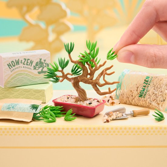 Miniatuur bonsai boom met bruine stam en groene bladeren, omringd door steentjes en zakjes.