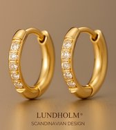 Paar kleine gouden oorringen met zirkonia steentjes, met de tekst LUNDHOLM SCANDINAVIAN DESIGN.